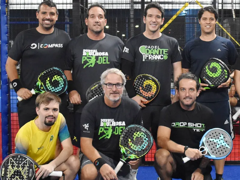 Grupo de jogadores com raquetes reunido na quadra do Padel Center